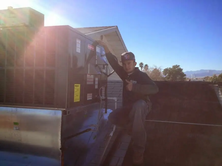 HVAC technician performing Boiler Repair on a rooftop unit in Bartlett